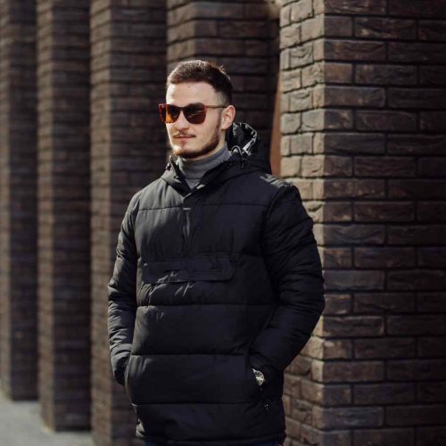 positive-smiling-young-male-stylish-clothes-standing-outside-alone-near-wall-urban-building-speaking-mobile-phone (1)