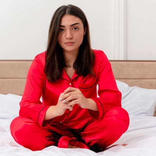 young-beautiful-woman-red-pajamas-sitting-bed-looking-camera-with-serious-face-bedroom-interior-light-background (1)